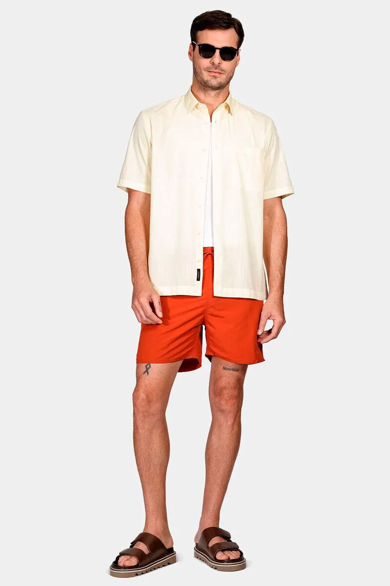 modelo usando camiseta branca e uma camisa com uma bermuda em um fundo branco