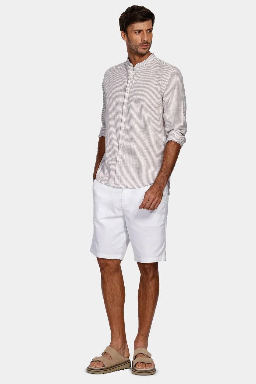modelo usando uma camisa e bermuda branca em um fundo claro