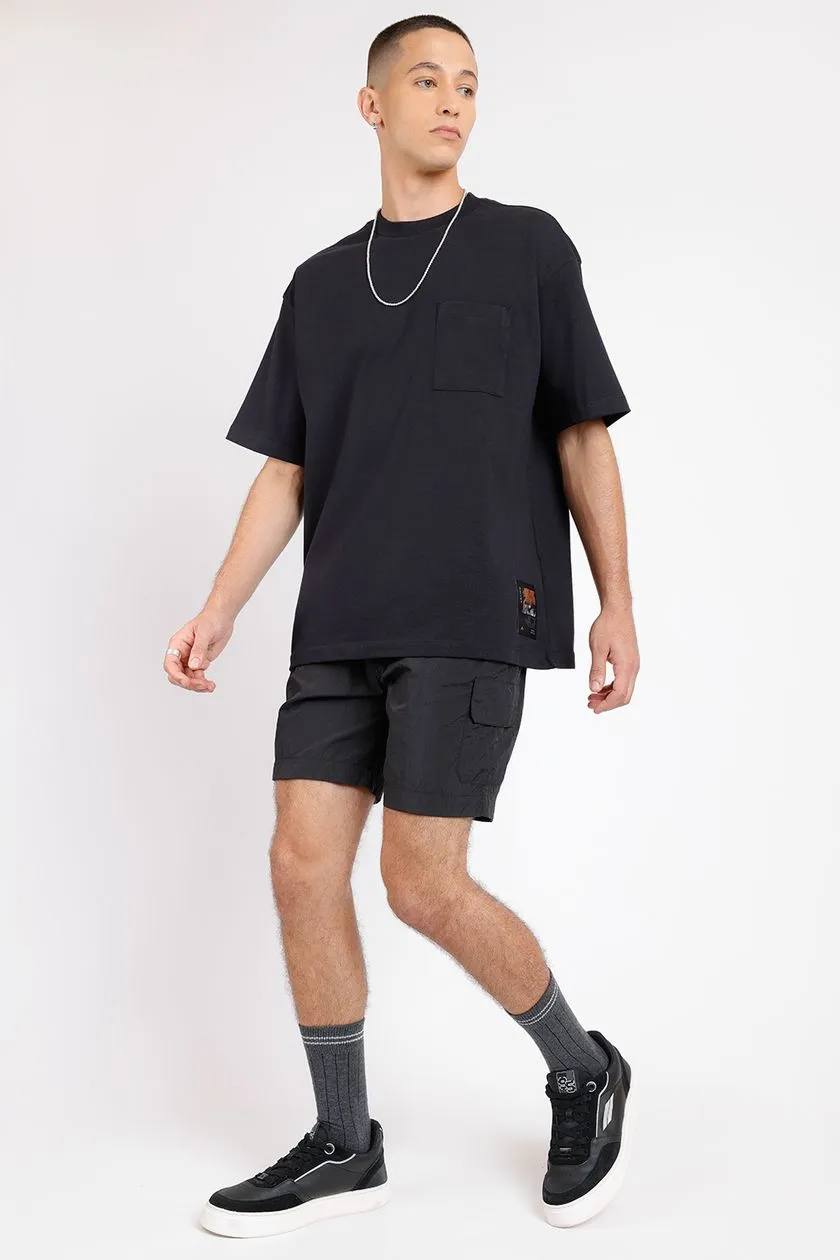 modelo usando uma camisa oversized e bermuda preta em um fundo branco