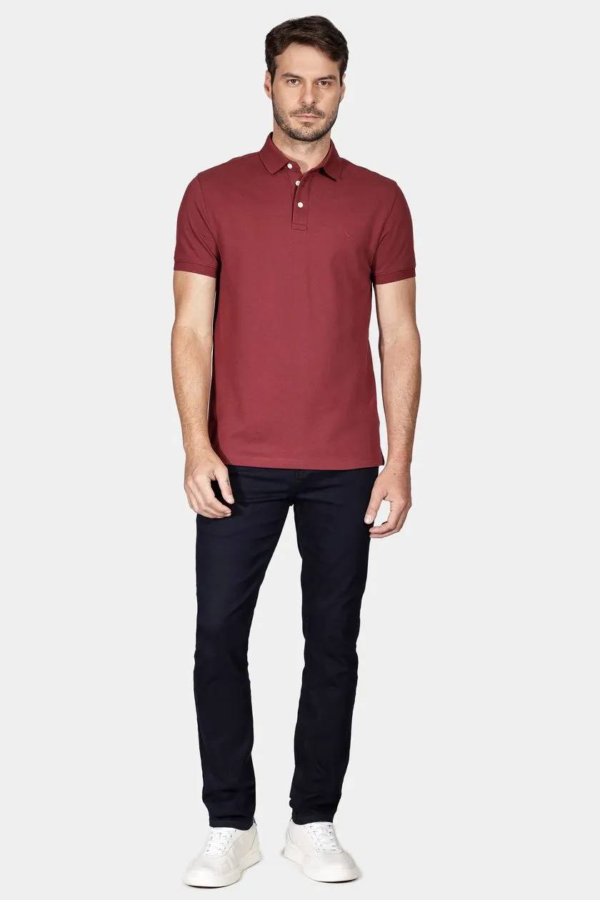 modelo usando uma polo bordo e calça jeans