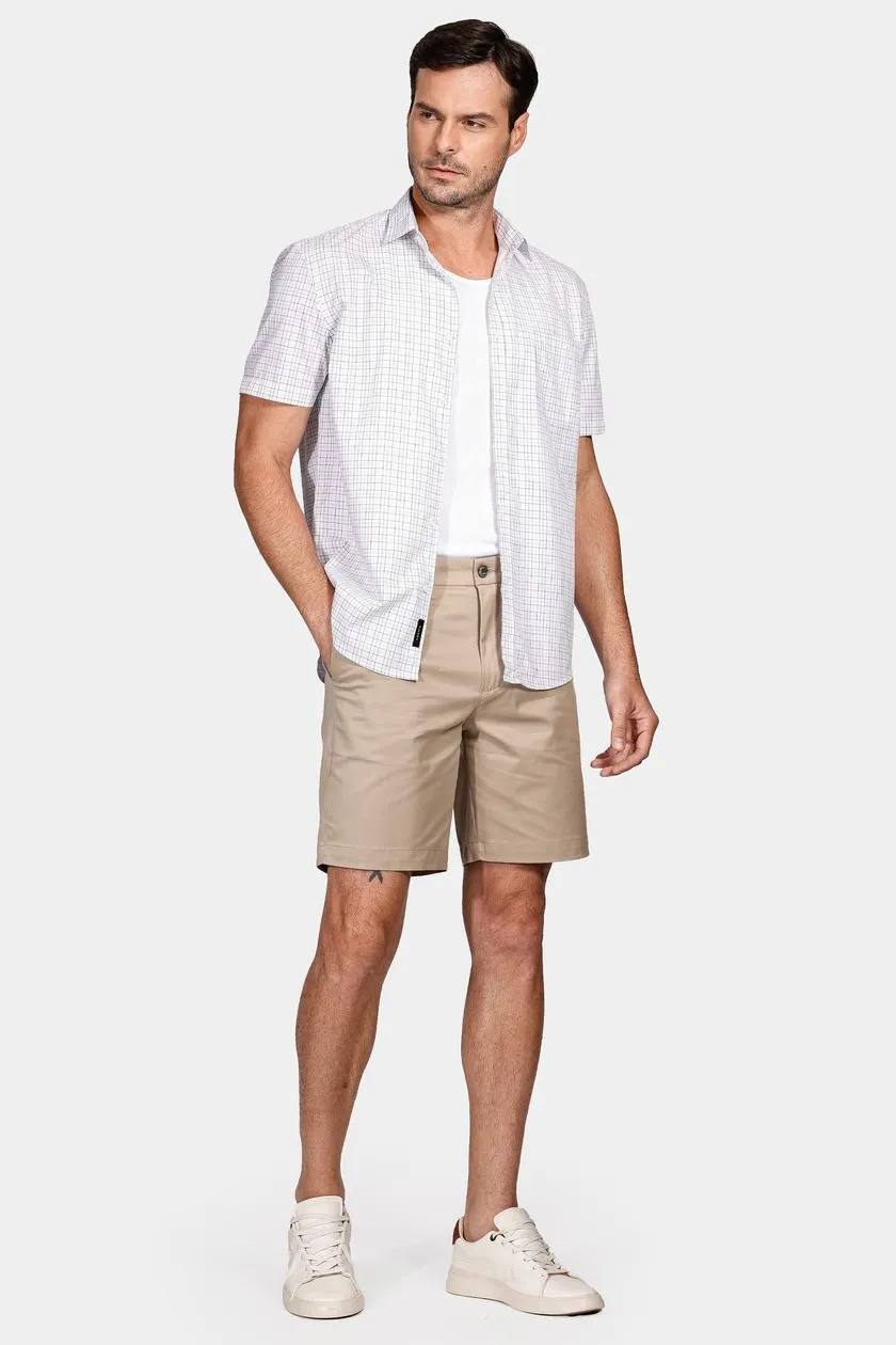 modelo de camisa e camiseta de sobreposição junto de uma bermuda em um fundo branco