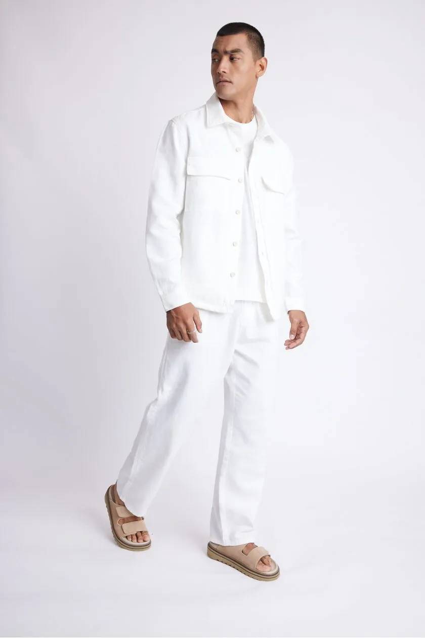 modelo usando roupas all white com uma sandalia em um fundo claro 