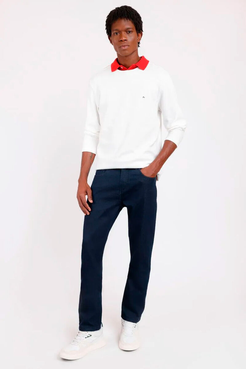 modelo usando uma camisa laranja por baixo de uma blusa branca e calça jeans slim em um fundo branco 