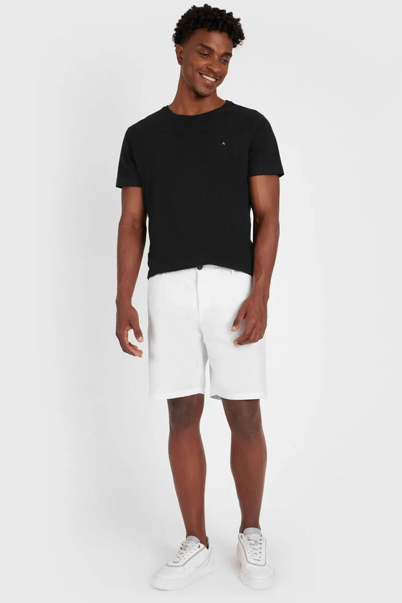 modelo usando uma bermuda em corte reto e uma camisa preta basica em um fundo branco