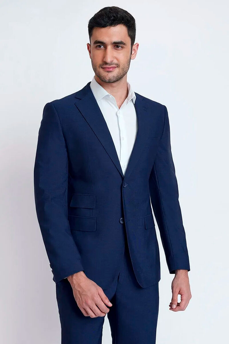 modelo usando um costume azul escuro com uma camisa branca por baixo em um fundo branco 