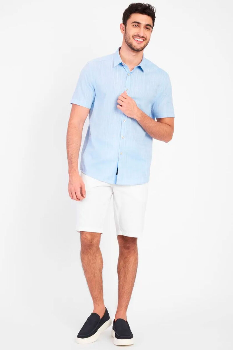 modelo usando uma camisa azul clara com bermuda branca