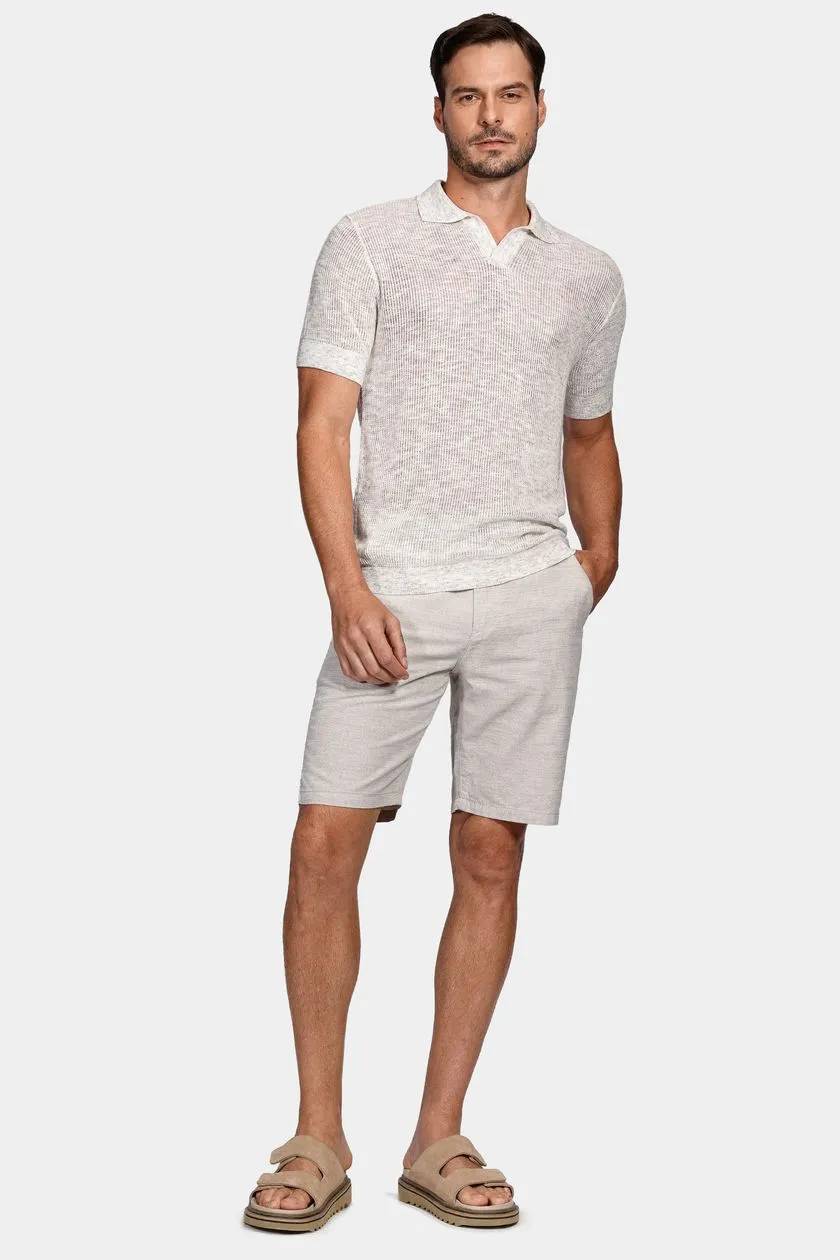 modelo usando uma blusa de tricot e bermuda em um fundo branco