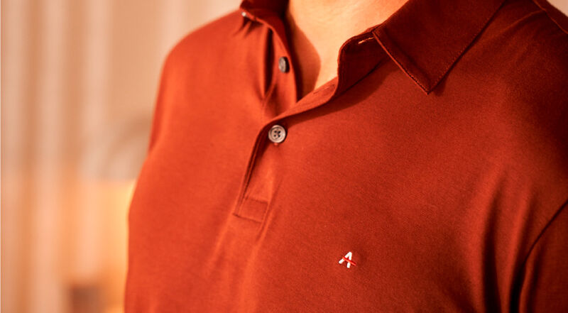 modelo usando uma camisa polo vermelho no tecido pima