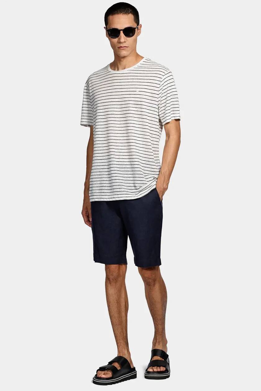 modelo de camisa listrada e bermuda junto de óculos escuros em um fundo branco