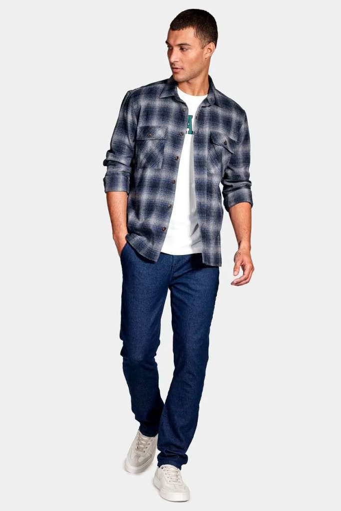 Homem vestido com camisa xadrez e jeans azul.