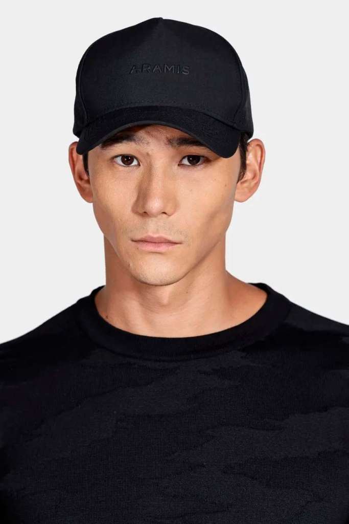 Homem usando boné preto da marca Aramis