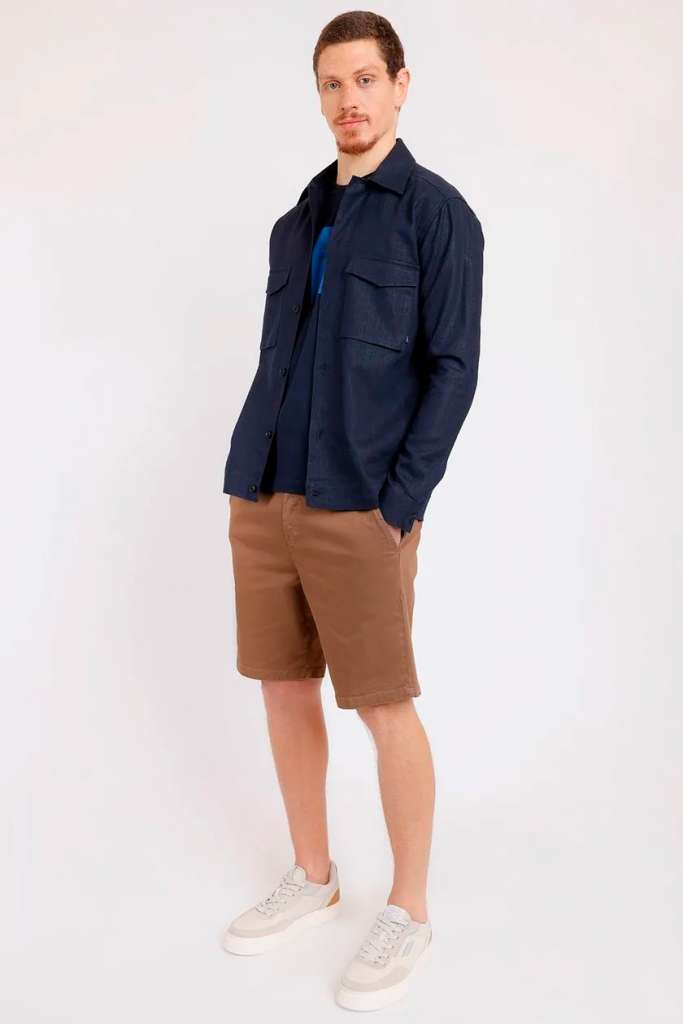 Homem com camisa azul e shorts marrons em pé