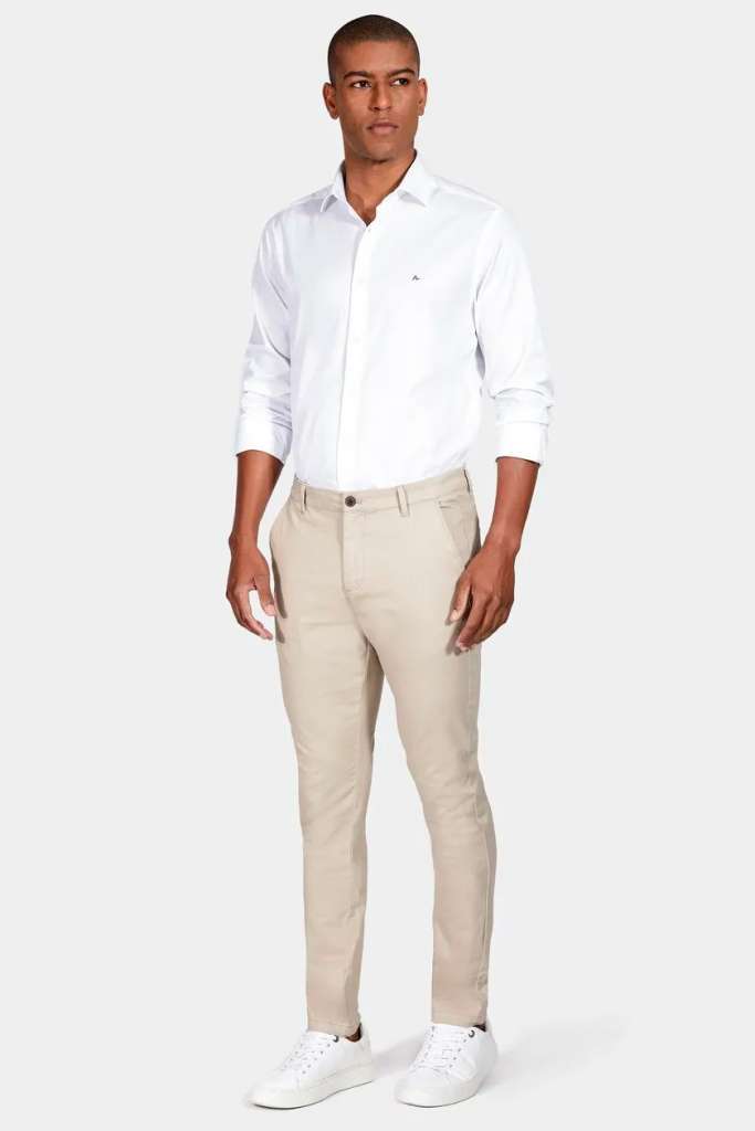 Homem vestido com camisa branca e calça bege