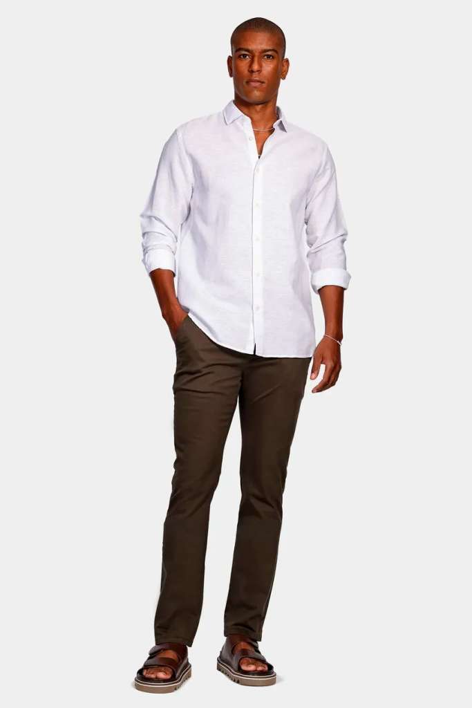 Homem com camisa clara e calça escura em pé
