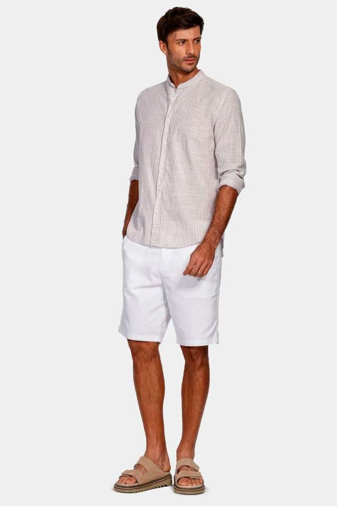 Homem em camisa listrada e shorts brancos