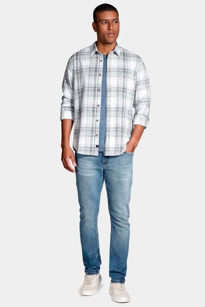 Homem com camisa xadrez e jeans claro sorrindo.