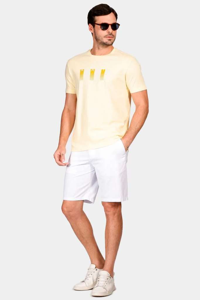 Homem usando camiseta amarela e shorts brancos.