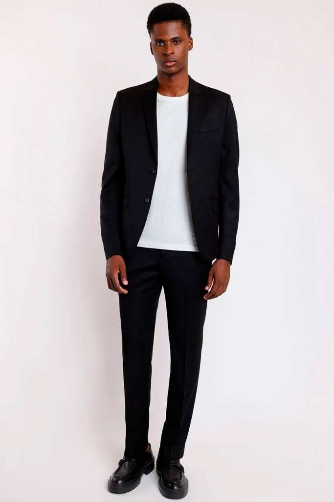 Homem vestido com terno preto elegante e camiseta branca.
