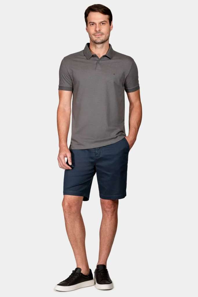 Homem em roupa casual, camiseta polo e shorts.