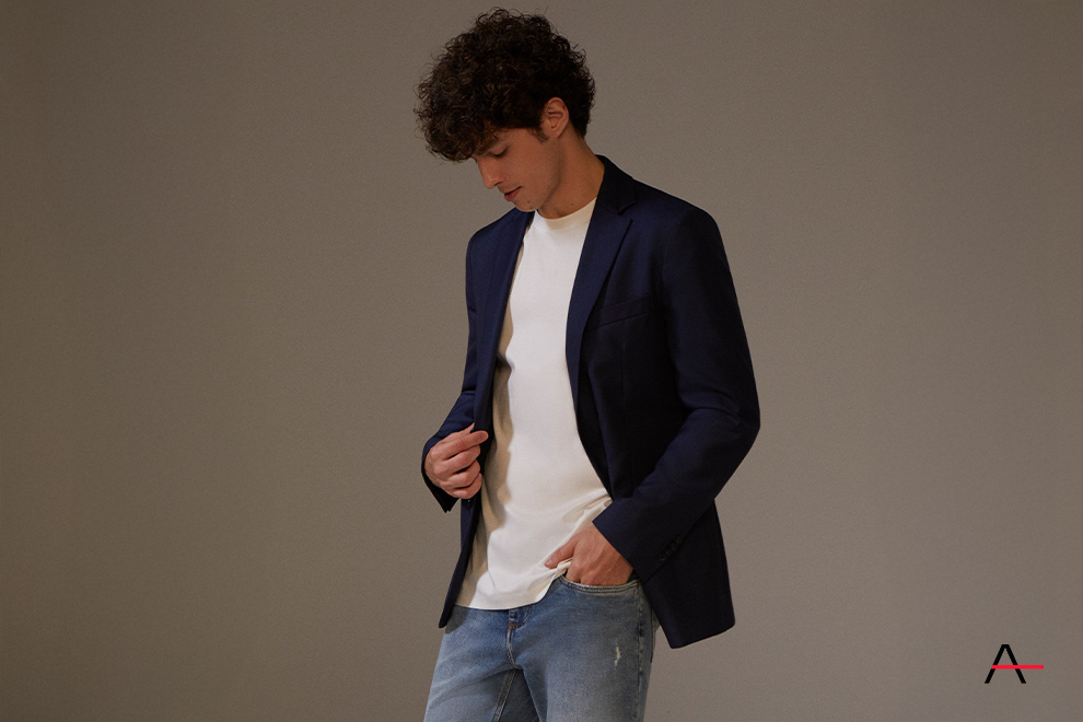 Homem com blazer azul e camiseta branca posando