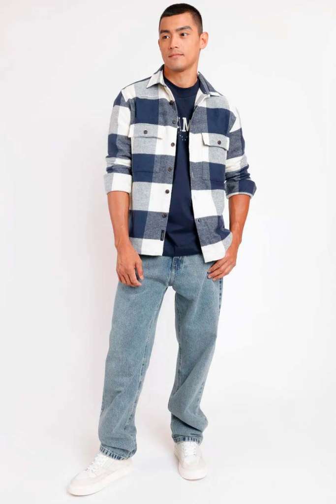 Modelo masculino usando camisa xadrez e jeans