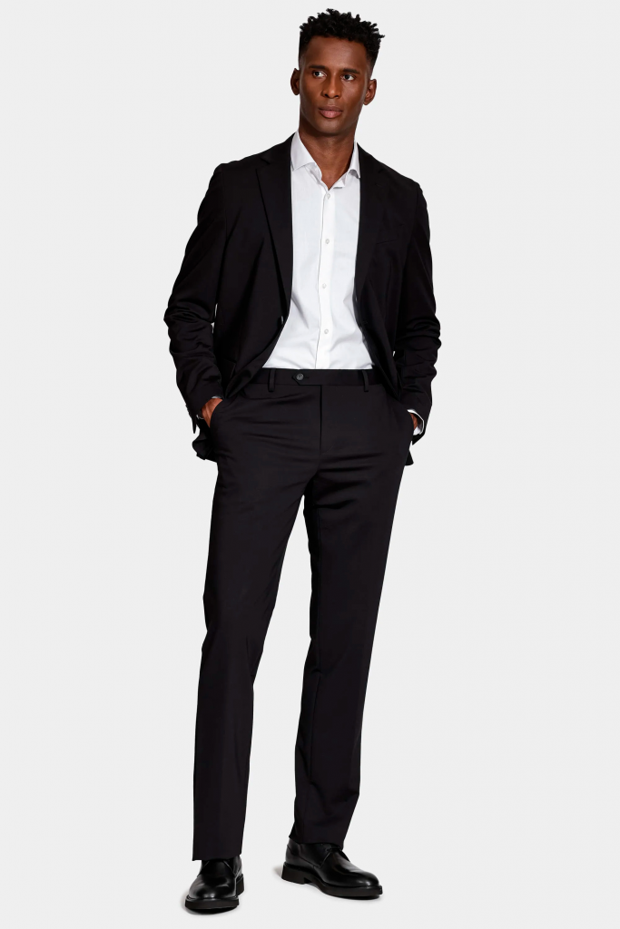 Homem elegante usando terno preto e camisa branca.
