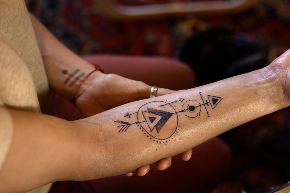 Tatuagem geométrica em braço feminino
