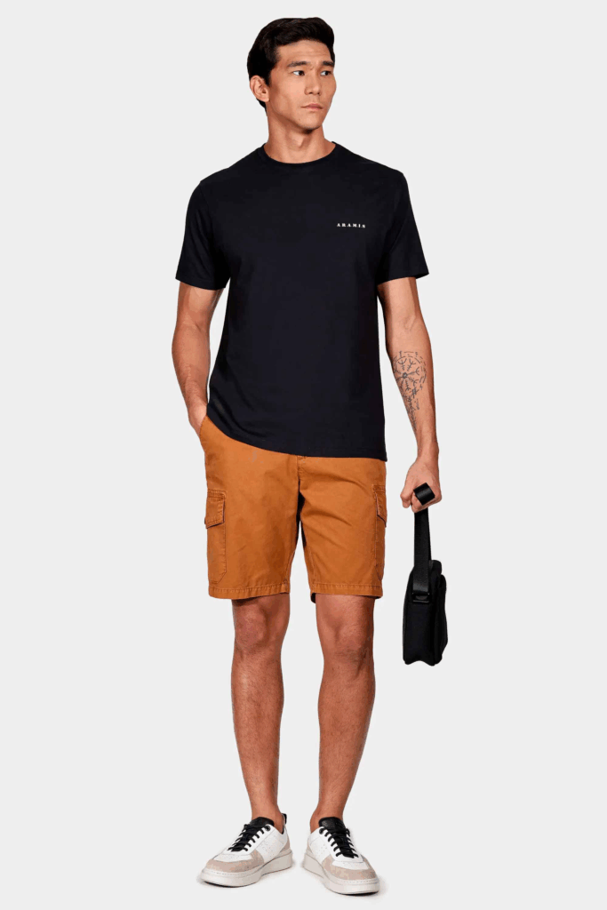 Homem usando camiseta preta e shorts caramelo