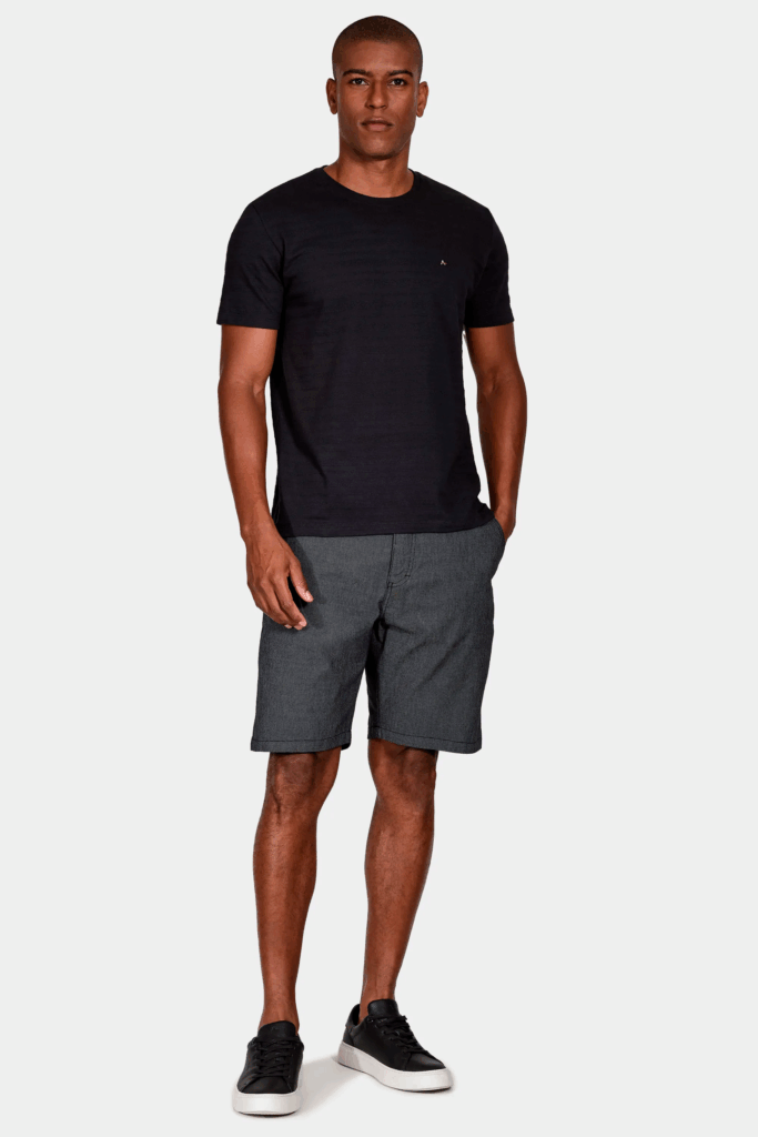 Homem em camiseta preta e bermuda cinza