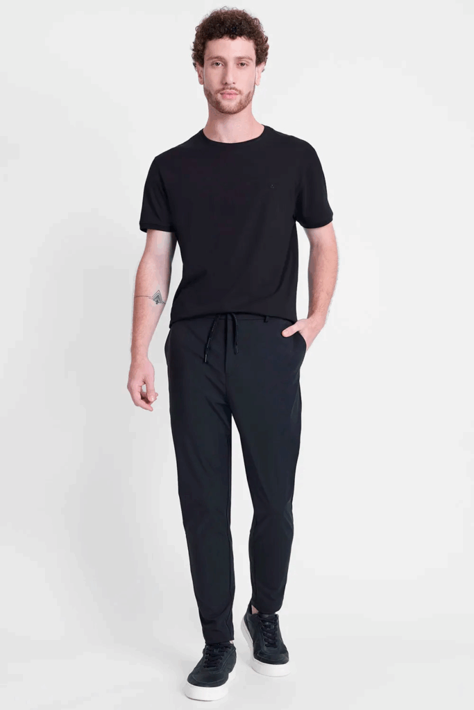 Homem com camiseta preta e calça preta em pé