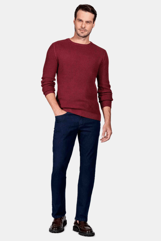 Homem usando suéter bordô e calça azul marinho