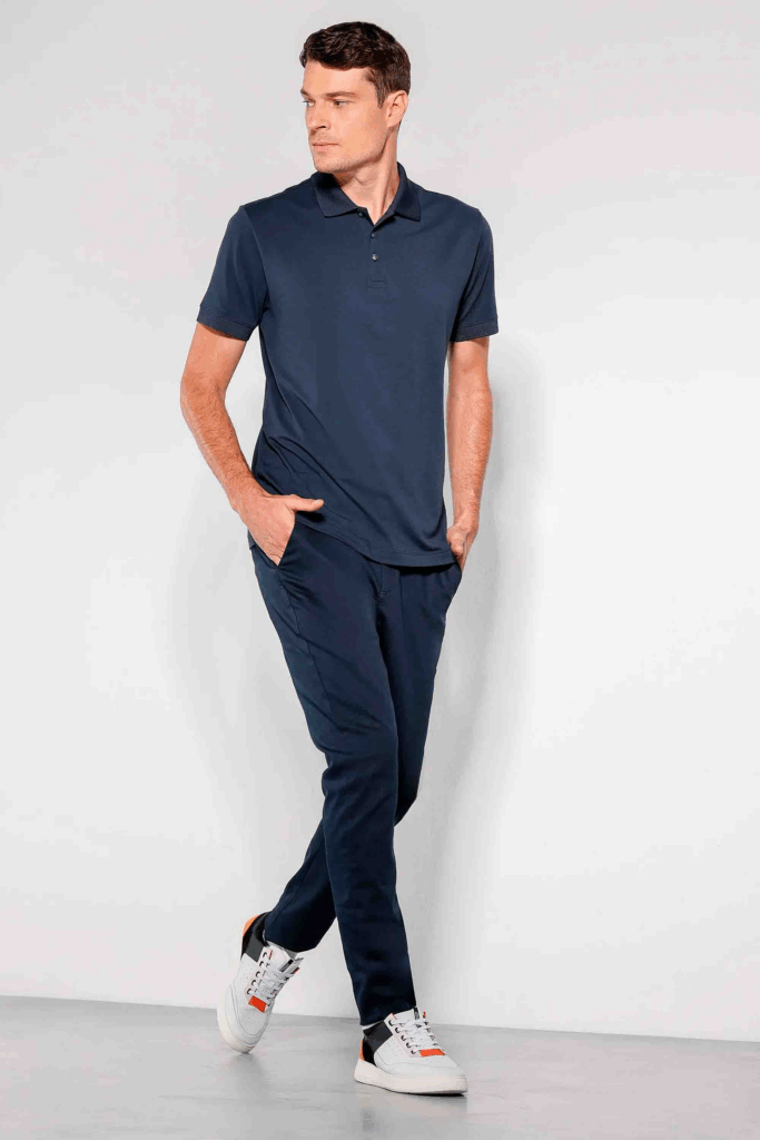 Homem vestindo polo azul e calça de moletom.