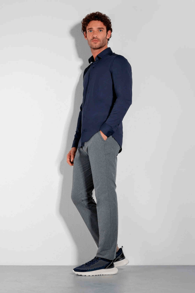 Modelo usando camisa azul e calça cinza