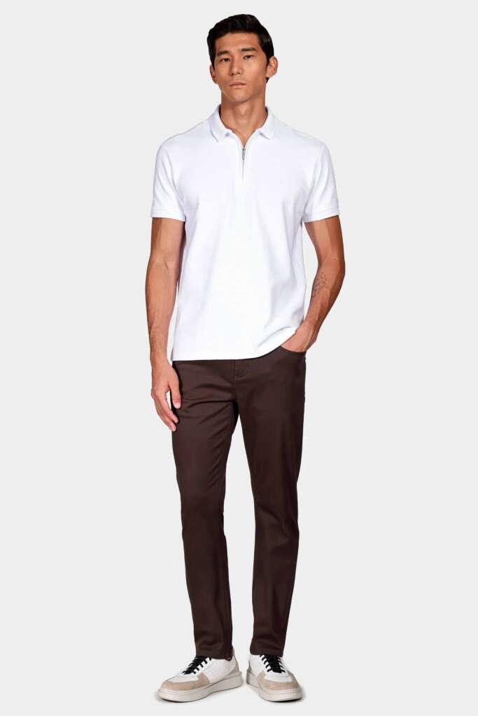 modelo masculino usando uma camisa polo branca e calça 5 pocket em um fundo branco 