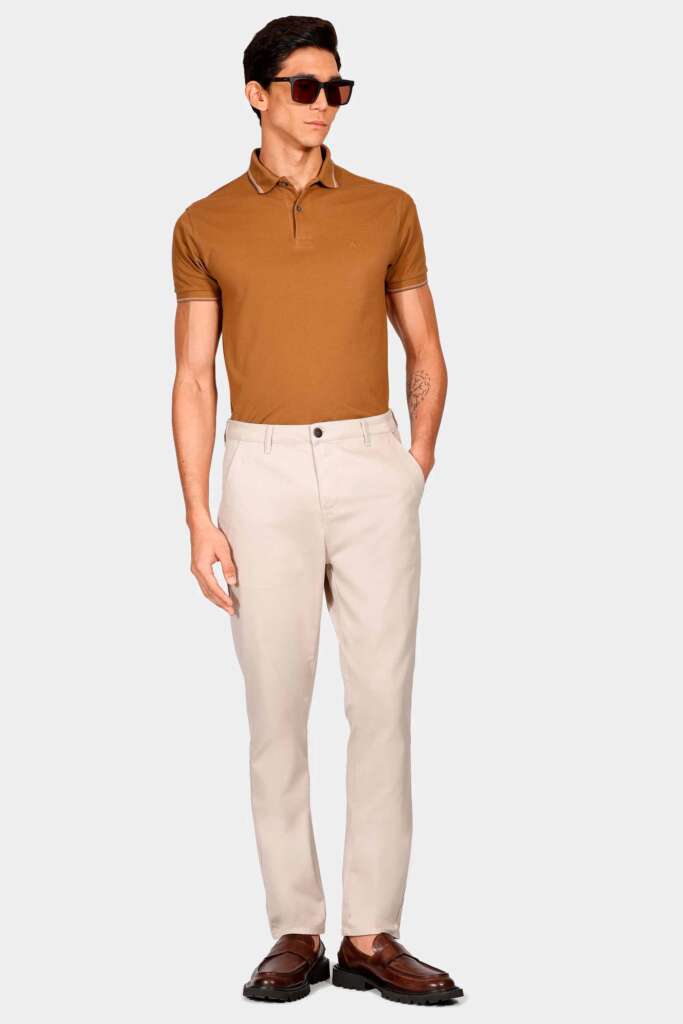 modelo masculino usando uma calça chino cropped e polo em um fundo branco 