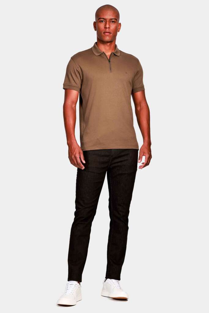 modelo masculino usando camisa marrom e jeans escuros em um fundo branco 