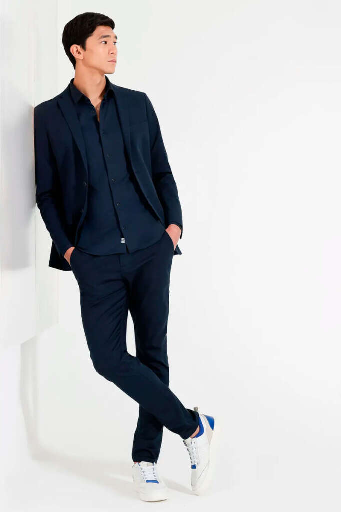 modelo masculino usando um paleto preto em um fundo branco 