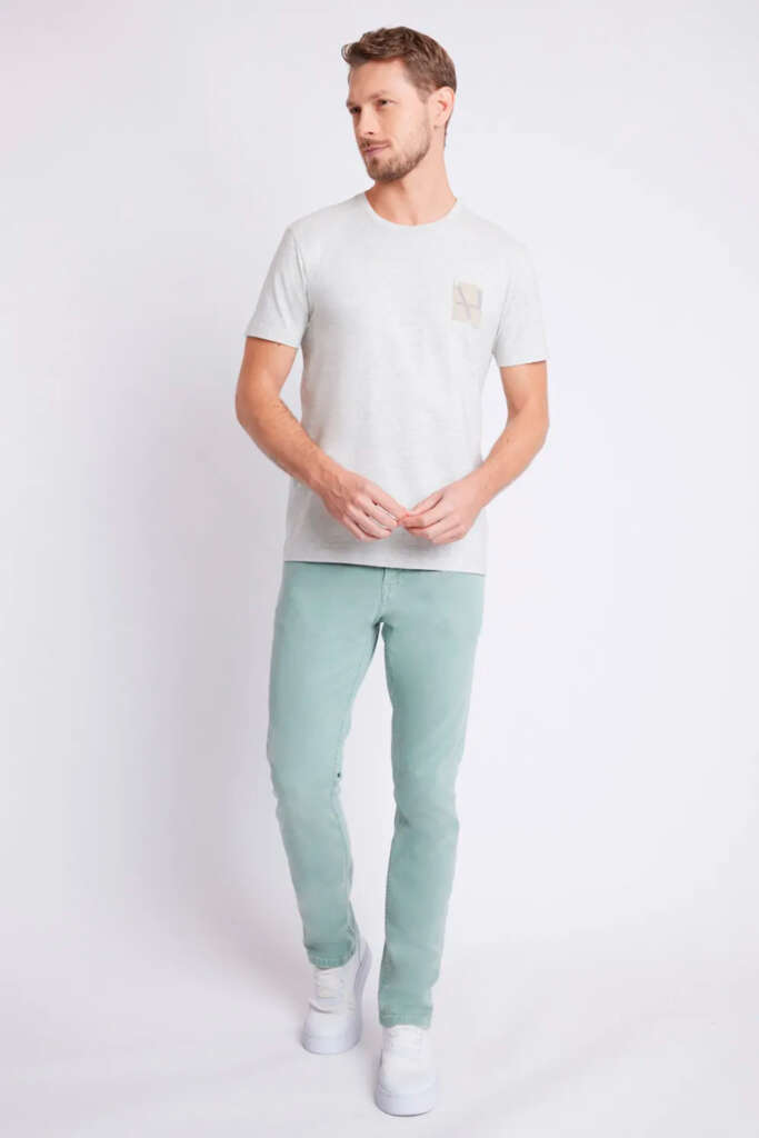 modelo masculino usando camisa branca e sarja em um fundo branco 