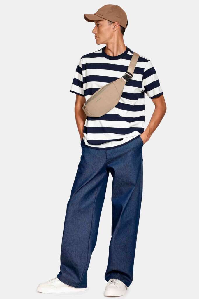 modelo masculino usando uma camisa listrada e calça chino em um fundo branco 