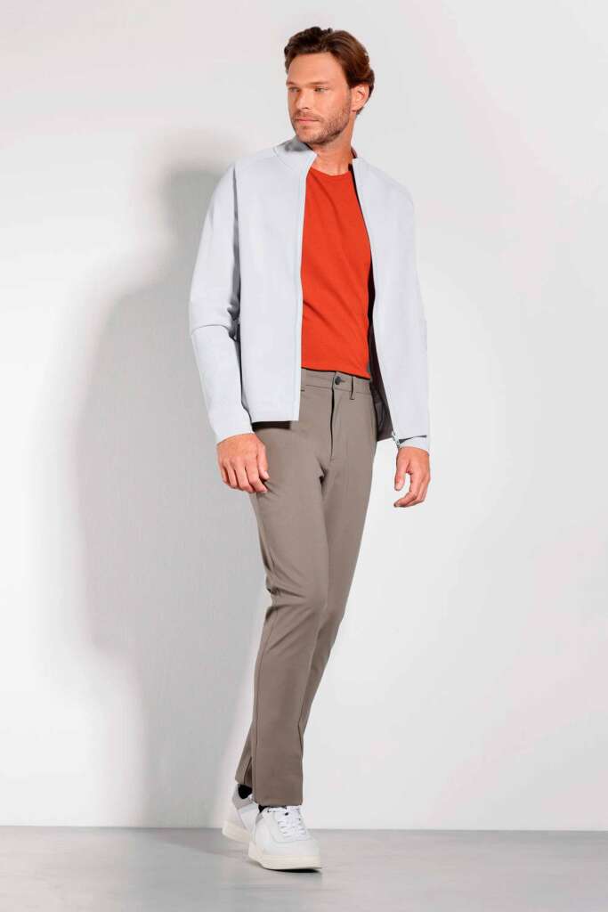modelo masculino usando uma camisa de tricot e calça cinza em um fundo branco 