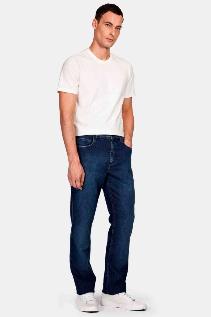 Homem em camiseta clara e jeans escuros.