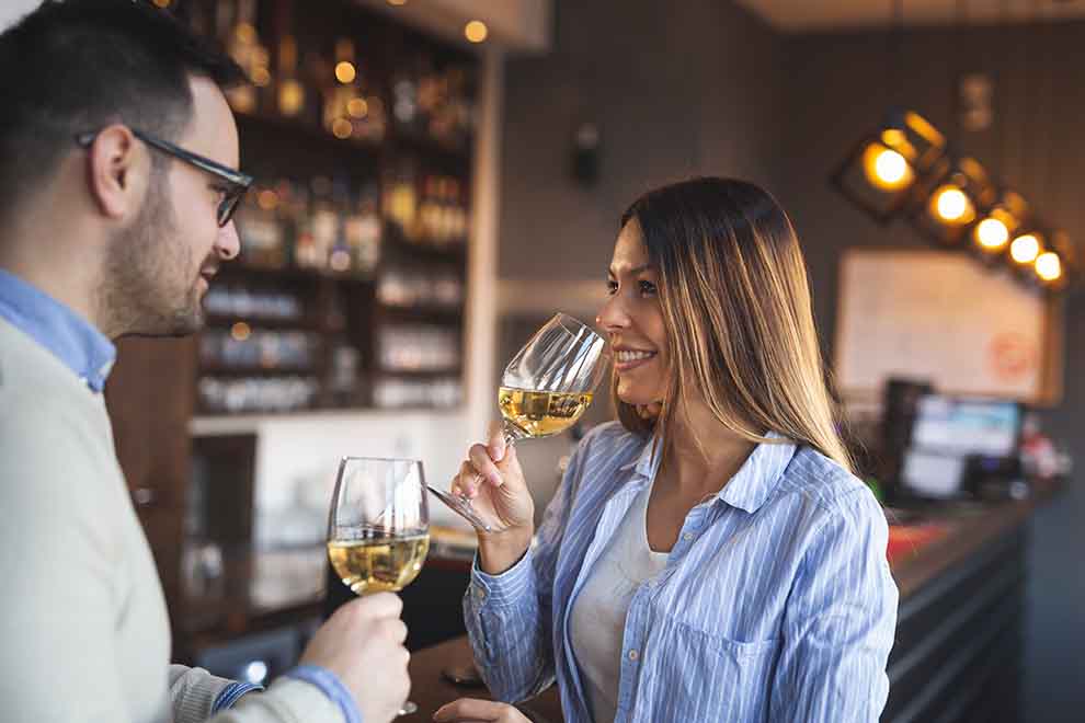 degustação de vinho Casal brindando com taças de vinho em bar