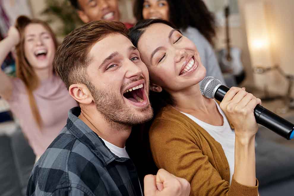 karaoke Casal cantando animado em festa com amigos.