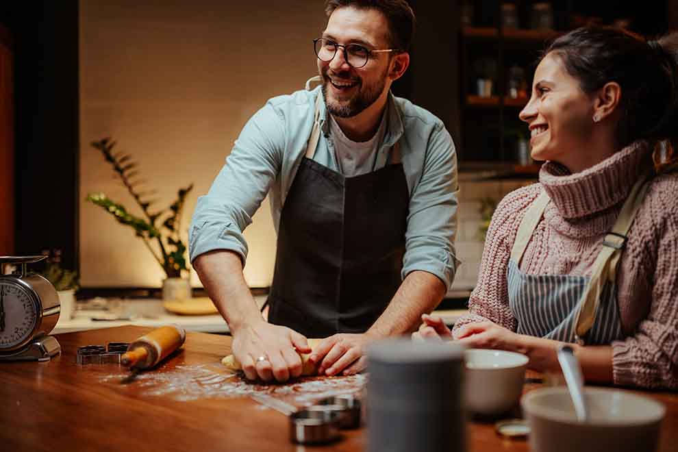 aula de culinaria Casal cozinhando juntos na cozinha, sorrindo.