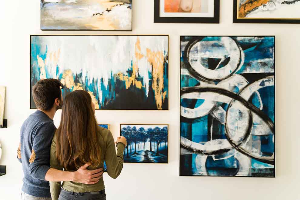 feira de artes Casal observando obras de arte na parede