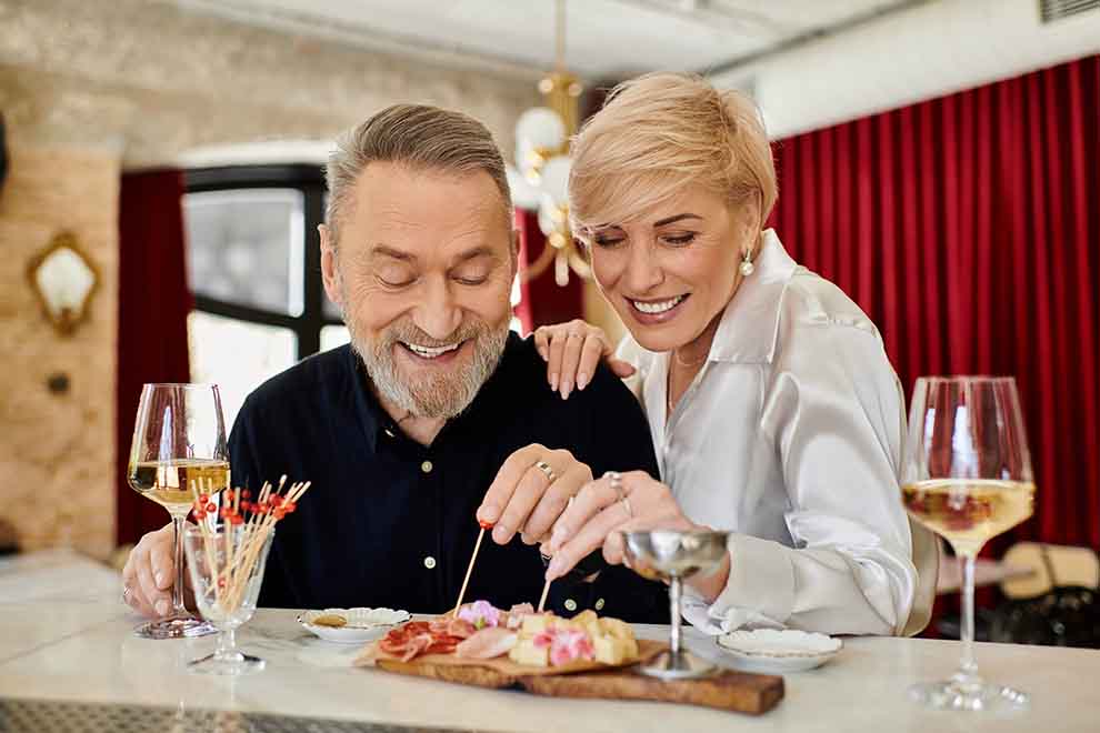 experiencia gourmet Casal sorridente compartilhando petiscos em um bar
