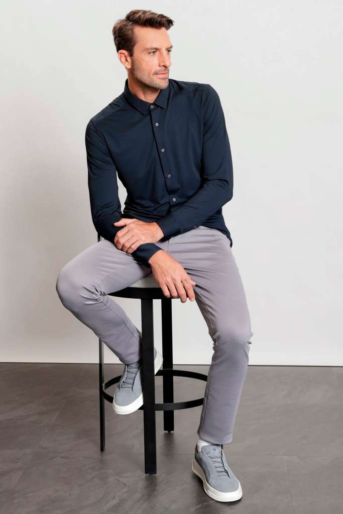 modelo masculino usando uma camisa de manga longa e calça jeans escura, junto de um tenis simples todos da linha Urban 