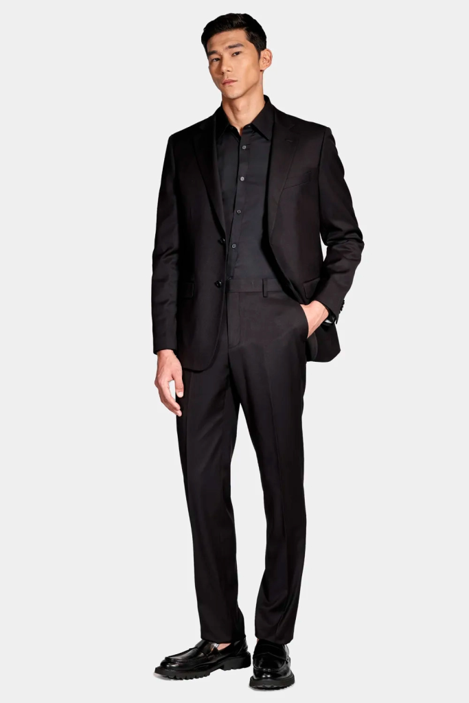 modelo masculino usando um terno preto em um fundo branco 