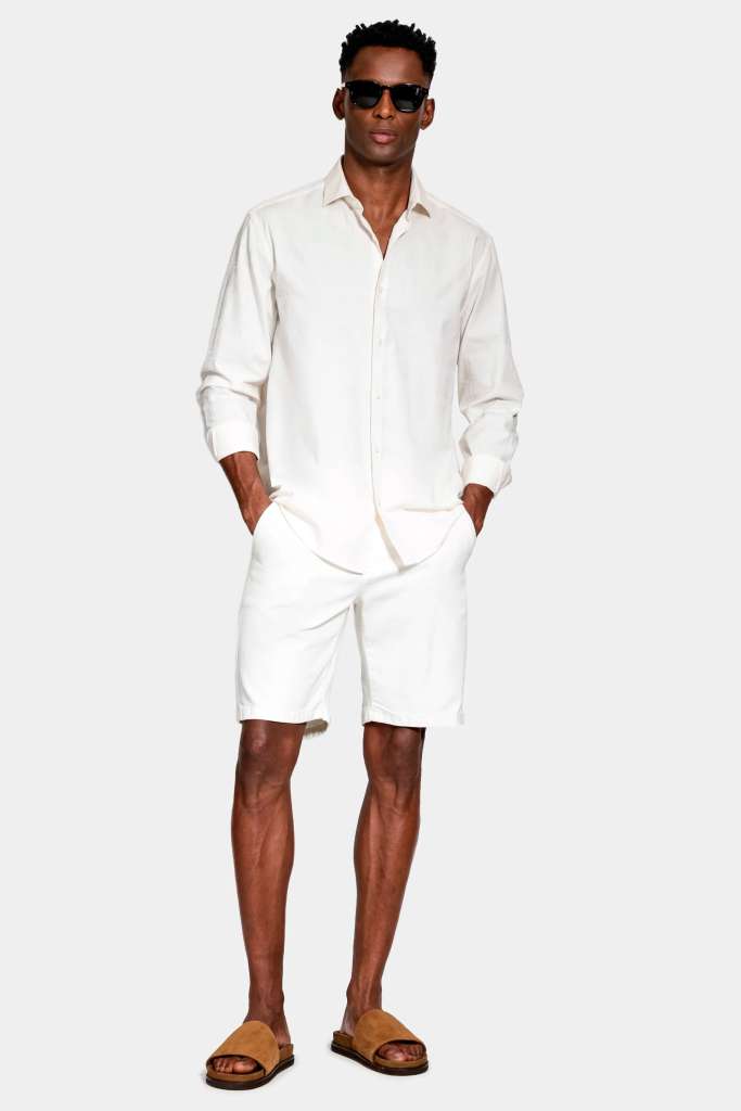 modelo masculino usando uma camisa de manga longa e uma bermuda em um fundo branco