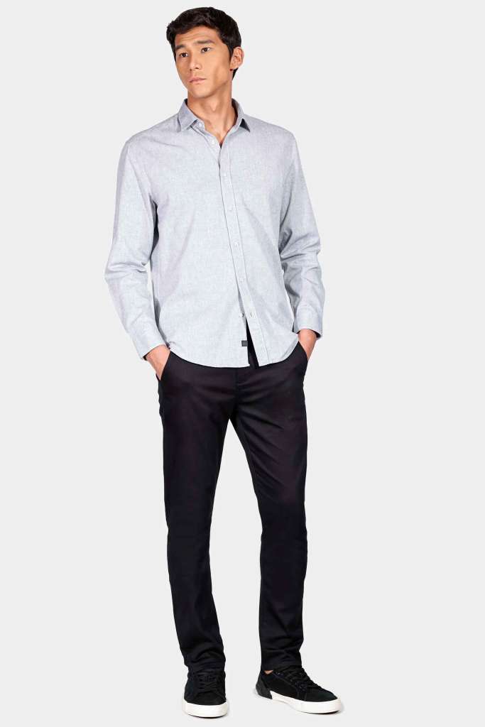 modelo masculino usando uma camisa em cor neutra e calça alfaiataria preta em um fundo branco 